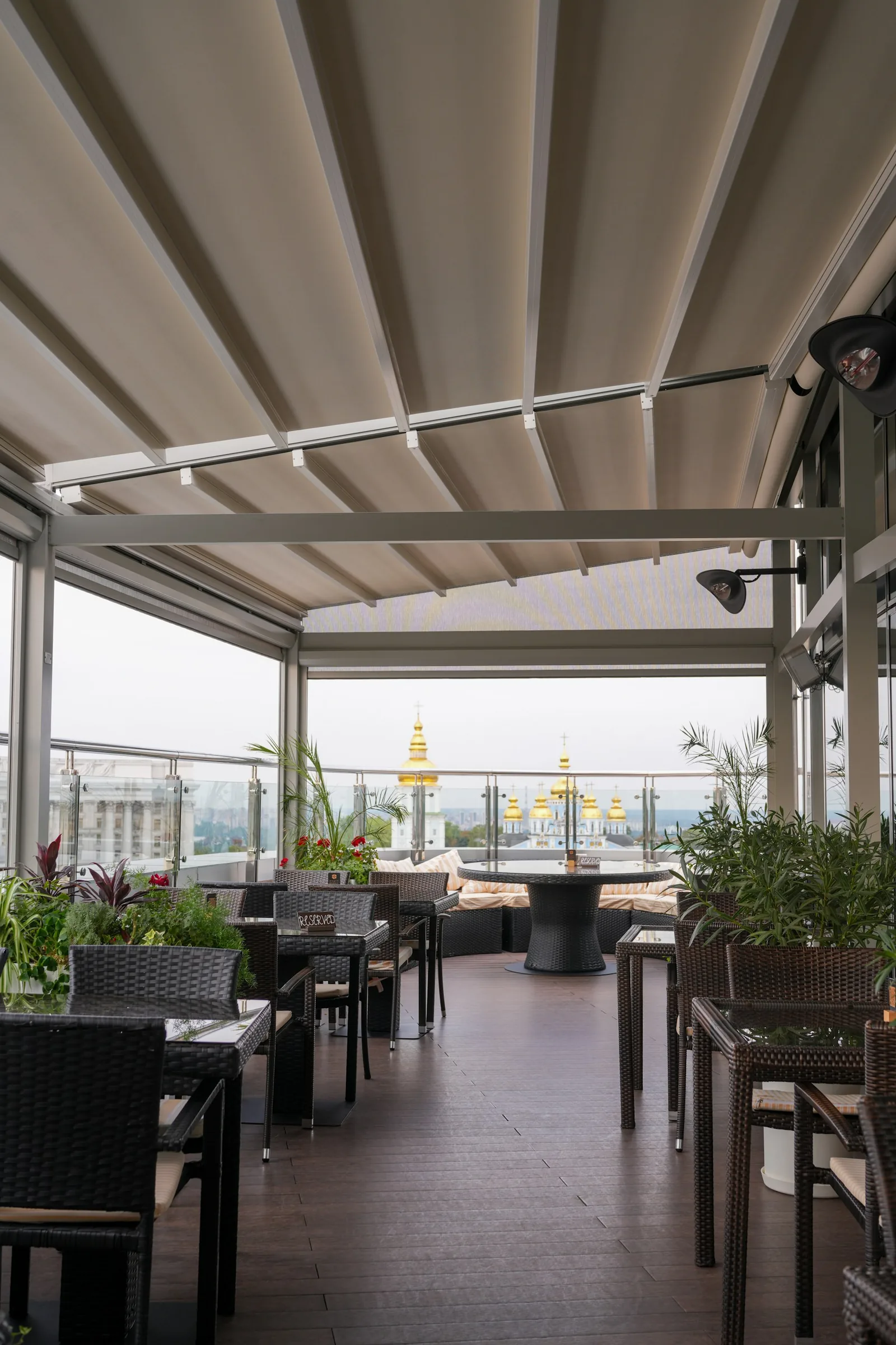 Überdachte Dachterrasse eines Restaurants mit Glaswänden