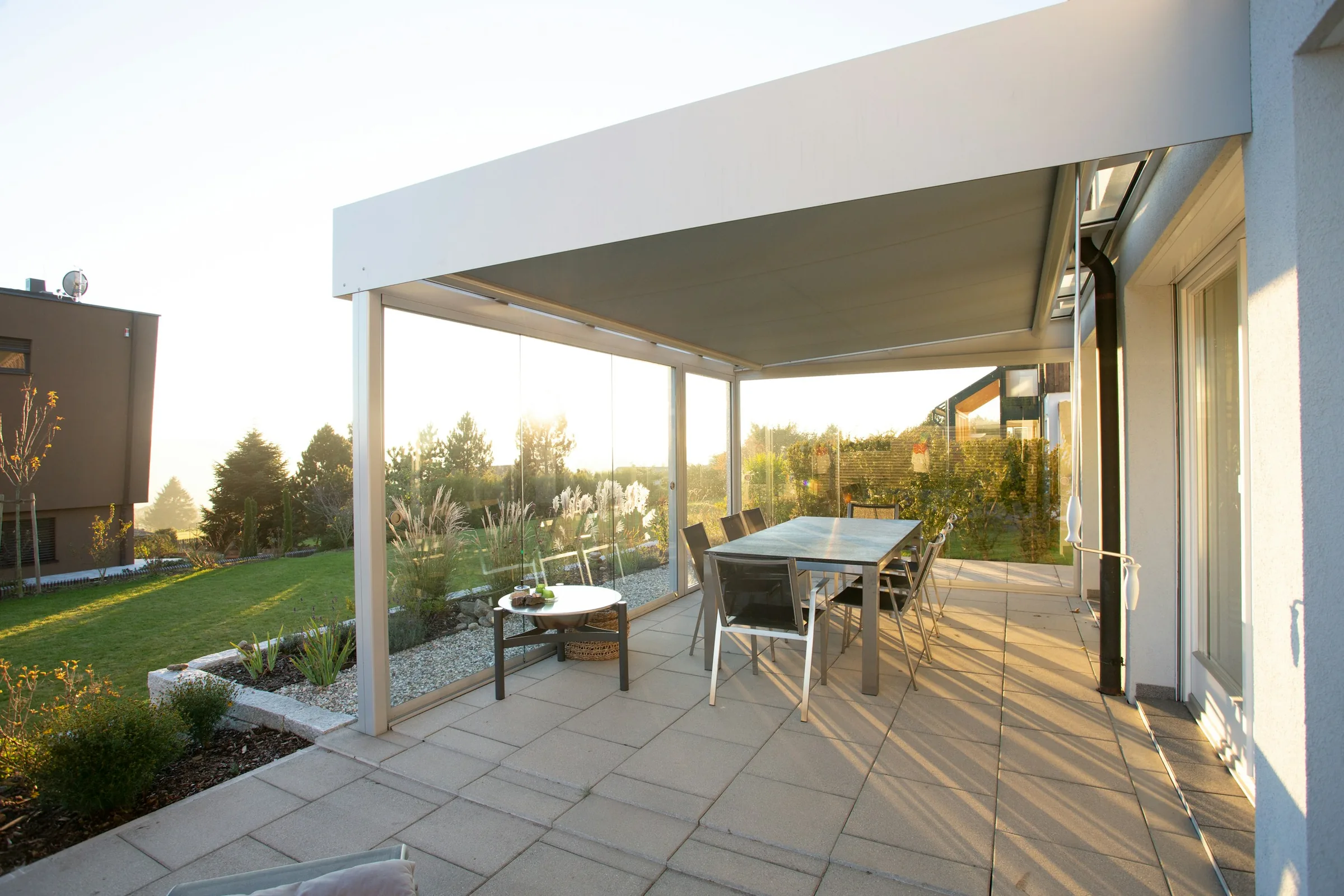 Terrassendach mit Glasschiebewänden an einem modernen Haus