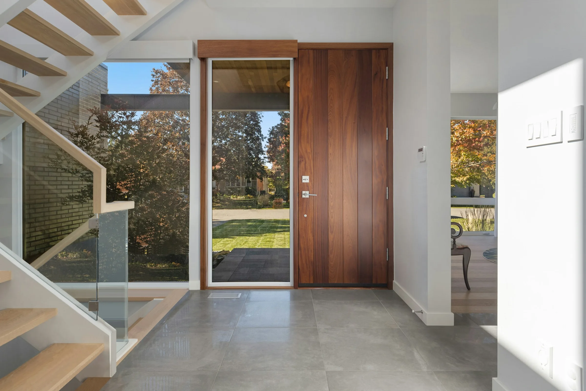 Eingangsbereich mit raumhoher Holz-Pivot-Tür und Glaselement